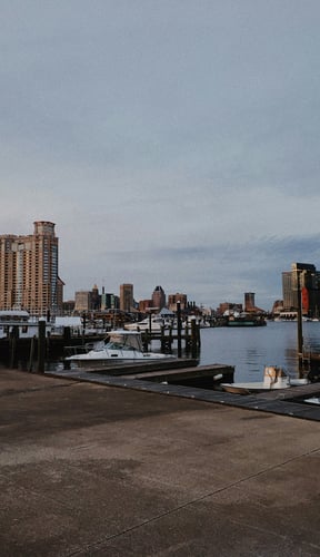 Baltimore inner harbor with boats and city skyline at dusk