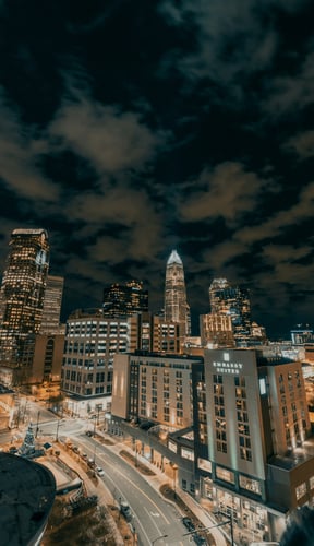 Charlotte uptown skyline lit up at night under dramatic clouds